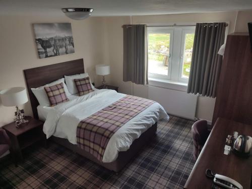 een hotelkamer met een bed en een raam bij Lochmaddy Hotel in Lochmaddy