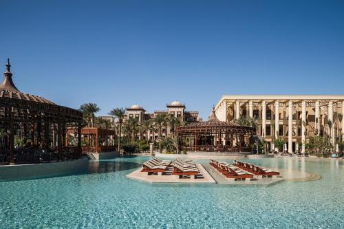 Al Kasr Sahl Hasheesh في الغردقة: مجموعة من كراسي الاسترخاء في الماء في منتجع