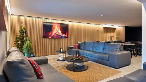 un salon avec un canapé bleu et un sapin de Noël dans l'établissement Hotel Catanies, au Pas de la Case