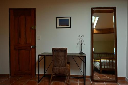 a dining room table with a chair and a mirror at Les Mourguettes in La Celle-sous-Gouzon