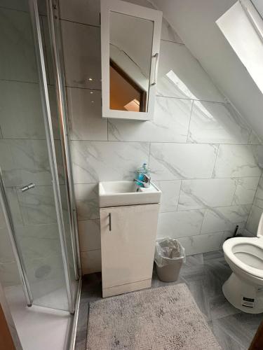 a bathroom with a sink and a shower and a toilet at Luton Town Homestay - Near AIRPORT & Train Station, High Speed Internet in Luton