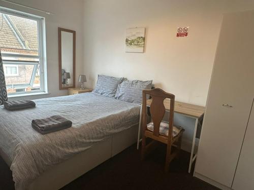 a bedroom with a bed with a desk and a chair at Luton Town Homestay - Near AIRPORT & Train Station, High Speed Internet in Luton