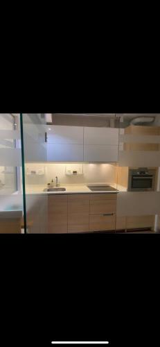 eine Küche mit weißen Schränken und einer Spüle in der Unterkunft Piso en Portugalete in Portugalete