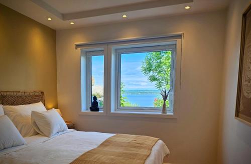 Un dormitorio con una cama y una ventana grande. en Helgøya Hideaway, 