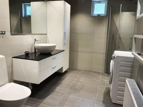 Lovely apartment, perfect for exploring Tjörn and Orust SE09153 في Varekil: حمام أبيض مع حوض ومرحاض