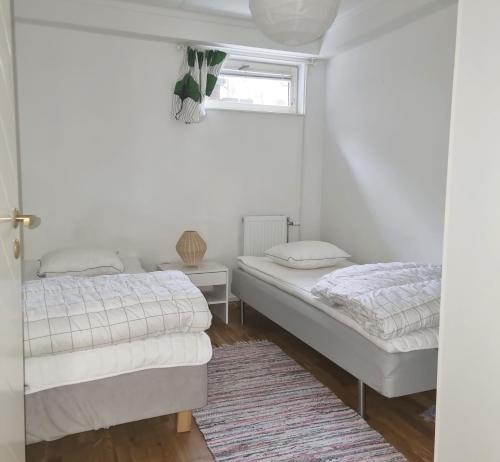 Lovely apartment, perfect for exploring Tjörn and Orust SE09153 في Varekil: غرفة نوم بها سريرين ونافذة