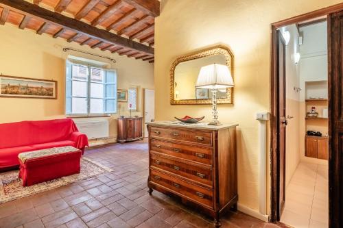 een woonkamer met een rode bank en een spiegel bij Atelier Lucca Centro in Lucca