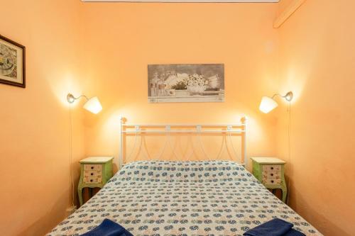 een slaapkamer met een bed met 2 nachtkastjes bij Atelier Lucca Centro in Lucca