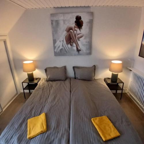 a large bed in a room with two lamps at Eksklusiv stort boende Suite 1 in Frederikshavn