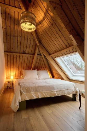 a bedroom with a bed in a wooden attic at Appartement C Rosita in Twisk