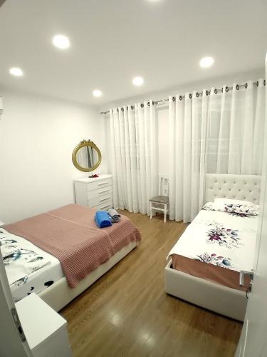 Serendipity Apartment في تيرانا: غرفة نوم بها سريرين ومرآة