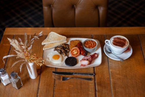 a breakfast plate of eggs and toast and a cup of coffee at The Woodborough Inn in Winscombe