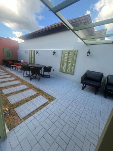 un patio con tavoli e sedie e una finestra di Pousada Grão & Vinha a Espirito Santo Do Pinhal