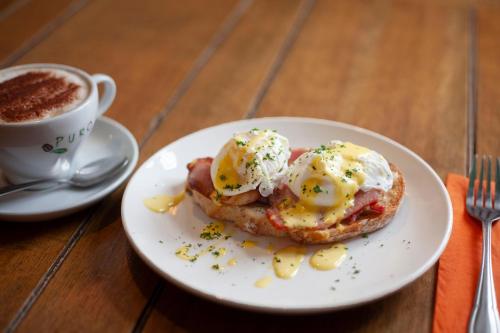 a plate with an egg sandwich and a cup of coffee at The Woodborough Inn in Winscombe
