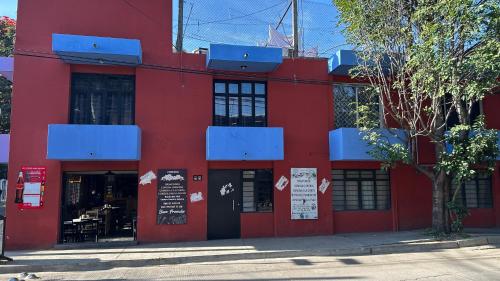 a red building with a restaurant on a street at Tulipán Azul Depa Renovado 2 Recámaras in Oaxaca City