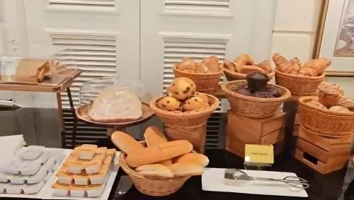 a table with baskets of bread and other foods at Luxe Avenue Hotel in Dubai