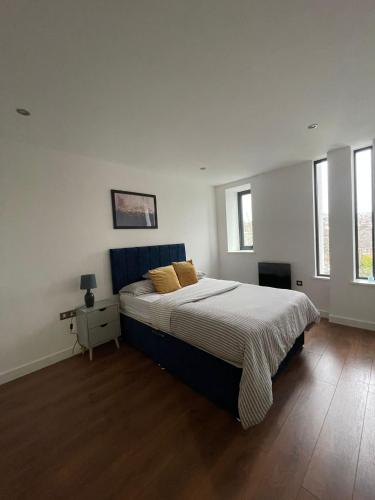 a bedroom with a large bed and two windows at Nottingham Central Accommodation in Nottingham