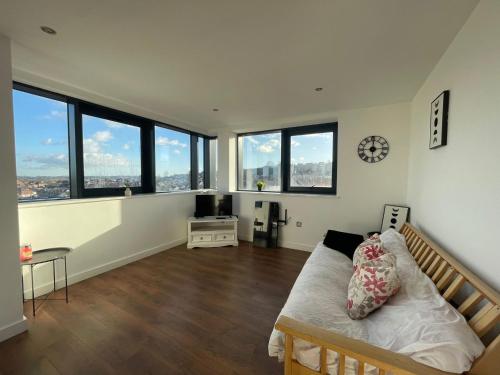 een grote kamer met een bed en een aantal ramen bij Forest Gate Nest Nottingham in Nottingham