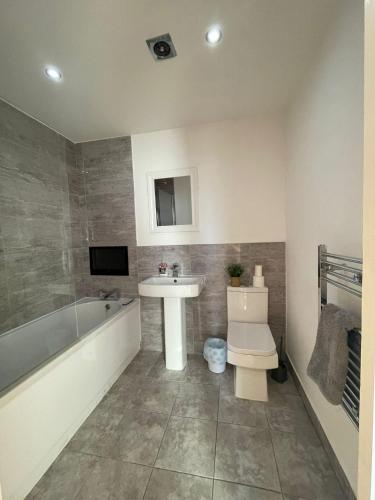 a bathroom with a tub and a sink and a toilet at Nottingham Central Accommodation in Nottingham