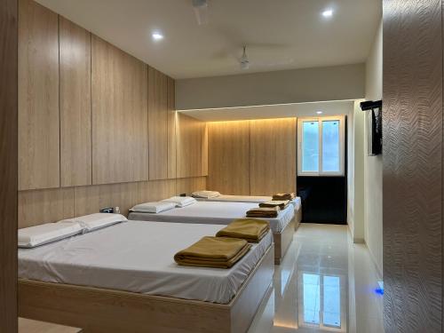 NP Residency في كومباكونام: غرفة بثلاث اسرة عليها مناشف