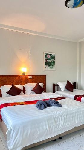 two beds in a hotel room with two bedsvisor at Book Lanta House in Ban Ru Yai