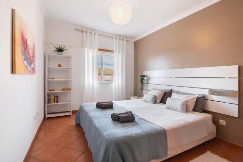 een slaapkamer met een groot bed met twee zakken erop bij Tamara's Apartment in Armação de Pêra