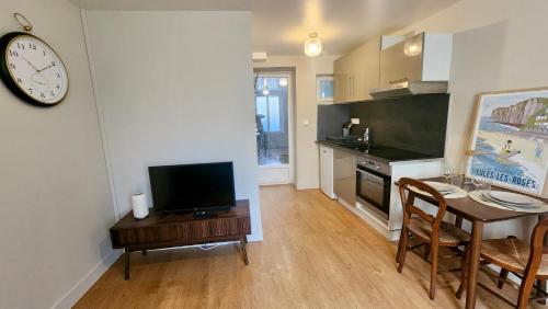 Le Moulin - Appartement cosy proche plage - Veules-les-Roses في فول-لي-روز: مطبخ مع طاولة وساعة على الحائط