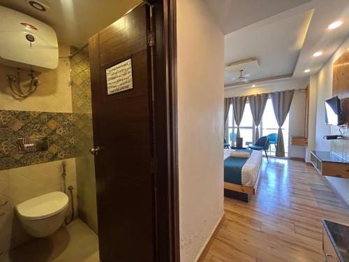 a bathroom with a toilet and a bed in a room at Pine Rock Hotel in Mussoorie Peaceful Stay in Mussoorie