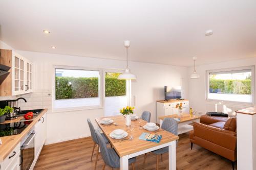 Una cocina y una sala de estar con mesa y sillas. en Alte Liebe 5, en Grömitz