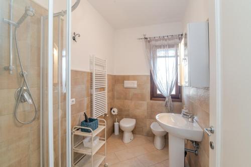 Un baño con lavabo, inodoro y ducha. en Casa Lucia San Teodoro 1, en Schifoni