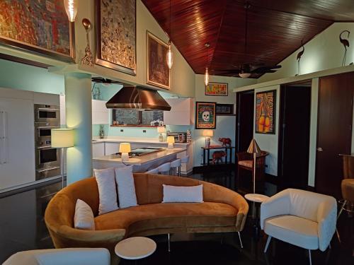 Villa Jardin في كيبوس: غرفة معيشة مع أريكة ومطبخ