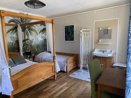 a bedroom with a canopy bed and a sink at Cosy Er Lann Gîte Séquoïa in Val Couesnon