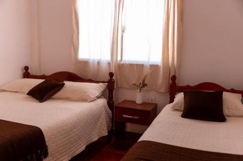ein Schlafzimmer mit zwei Betten und einem Fenster in der Unterkunft Hostal el rincón de cusi in Mina Pirquitas