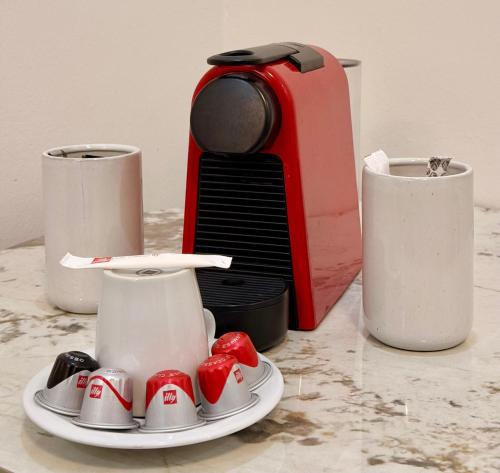 a white plate with strawberries on a table next to a toaster at Keur Ébène - Appartement Cosy à Ouakam Batrain in Dakar