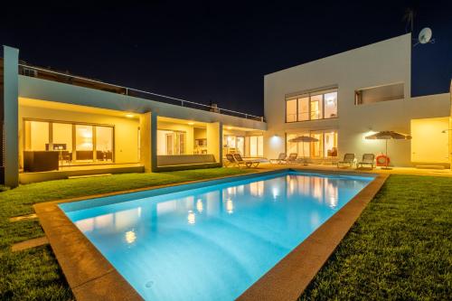 a swimming pool in front of a house at night at Villa L in Galé