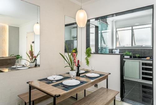 una sala da pranzo con un tavolo con due piatti di Confortável e bem localizado a 300m da praia a CFB