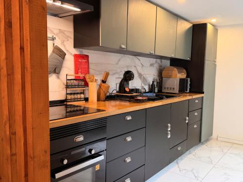 una cucina con armadi grigi e piano di lavoro di Queluz Maison Jacuzzi Escape a Queluz