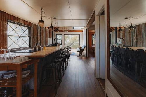 a kitchen with a long bar with black chairs at Secluded rustic 3-bedroom cabin on private land in Miramonte