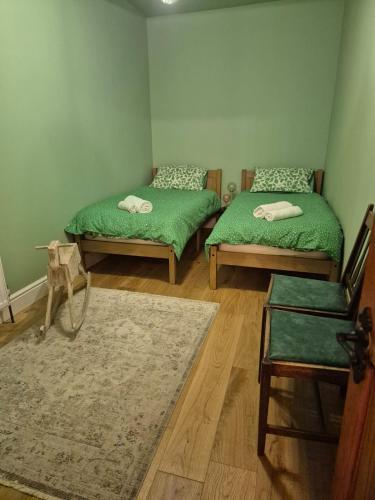a room with two green beds and a rug at The Ferns in Mitcheldean