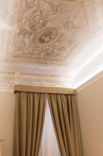 a coffered ceiling with a painting on the ceiling at Residenza Marchesi Pontenani in Florence