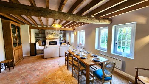een eetkamer met een tafel en een woonkamer bij Détente Famille Charme Normand - Maison de charme - Proche mer et plages in La Gaillarde