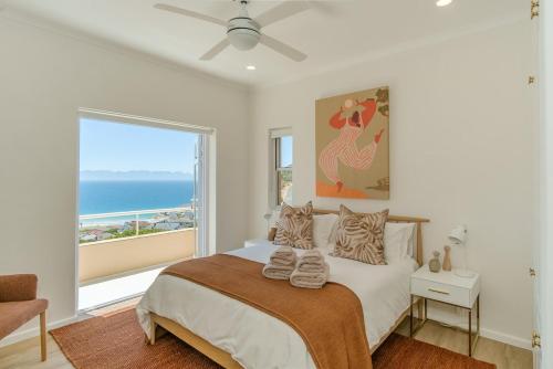 a bedroom with a bed with a view of the ocean at Ocean Villa Views Fish Hoek in Glencairn