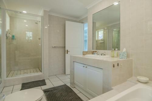 a bathroom with a toilet and a sink and a shower at Ocean Villa Views Fish Hoek in Glencairn