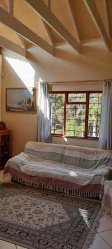 a bedroom with a large bed in a room with windows at Wilderness Phoenix Rising in Wildernis