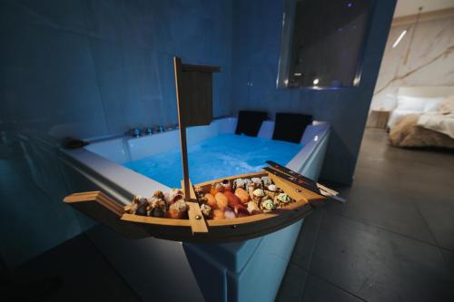 a bath tub with a tray of food next to it at Artemide Resort Spa - Private Villa & Spa Suites in Lido Di Fondi
