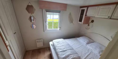 a small bedroom with a bed and a window at La casa du clos in La Bernerie-en-Retz