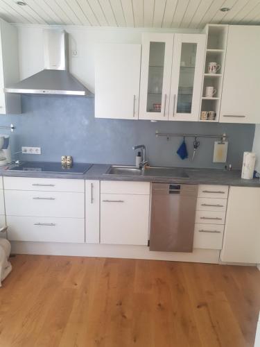 Im Alpennest في Niederdorla: مطبخ بخزائن بيضاء ومغسلة