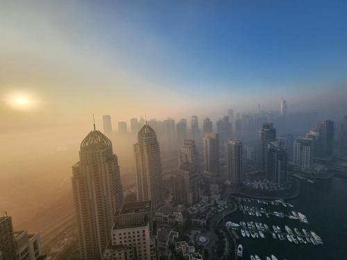 a view of a city in the fog with buildings at SOLARTE Luxe - Marina Gate - Spectacular Pools with Marina Views in Dubai