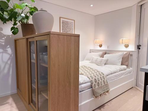a bedroom with a bed and a glass cabinet at Soft Stay Apartment in Bergen
