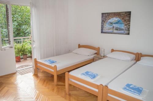 two beds in a room with a window at Ranko Apartments in Risan